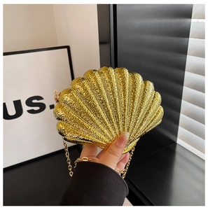Détail de la pochette de soirée dorée en forme de coquillage avec texture et chaîne
