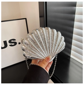 Détail du sac de soirée argenté en forme de coquille avec texture métallique et chaîne