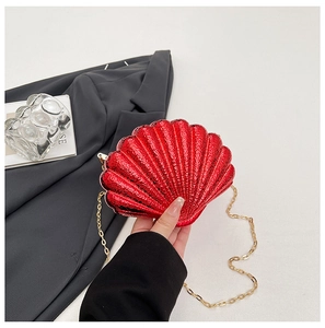 Détail du sac de soirée rouge brillant en forme de coquille avec sa chaîne dorée