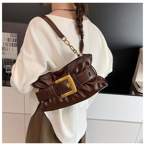 Detail of dark brown pleated handbag featuring a large vintage gold square buckle