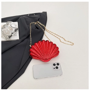 Détail de la pochette coquille rouge avec chaîne dorée à côté d'un smartphone pour la taille