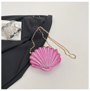 Détail du sac de soirée en forme de coquillage rose brillant avec chaîne dorée