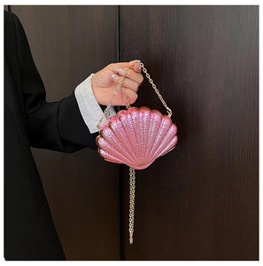 Vue détaillée d'une pochette de soirée rose en forme de coquille avec chaîne dorée