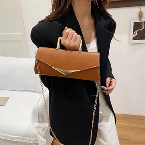 Brown leather crossbody bag with V-shaped gold buckle and elegant chain strap for women