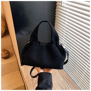 Detail of black suede cloud bag featuring matte finish and adjustable strap