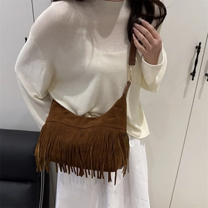 Brown suede bohemian crescent moon bag with fringe detail and flat shoulder strap