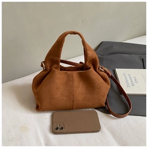 Brown suede tote bag size reference with phone showing adjustable strap and texture