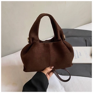 Detail of dark brown suede cloud bag with soft pleats and gold-tone hardware
