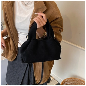 Chic black pleated shoulder bag with gold hardware shown on a camel coat outfit