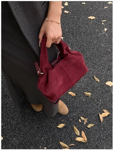 Sac nuage en daim bordeaux avec bracelet chaîne doré sur fond de rue automnale