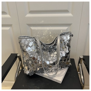 Détail d'un grand sac cabas argenté avec de gros sequins brillants sur une chaise