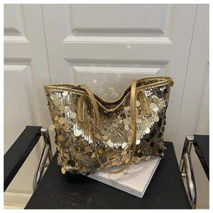 Détails de grandes paillettes dorées et fines bandoulières sur un sac fourre-tout