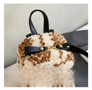 Detailaufnahme von flauschigem Plüschstoff und Leder Schleife mit goldener Hardware am Rucksack