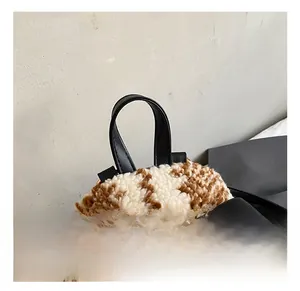 Detail eines Plüsch-Rucksacks mit Leopardenmuster, schwarzem Ledergriff und Goldnieten
