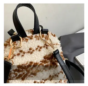 Details des Plüschrucksacks mit goldenen Metallhaken und Trageriemen aus schwarzem Leder