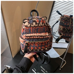 Detail des Plüsch-Mini-Rucksacks mit orange-blauen geometrischen Streifen und Ledergriff