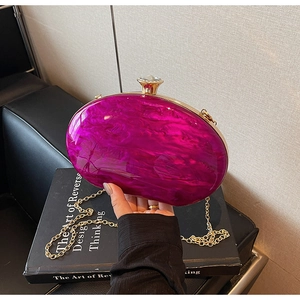 Macro detail of purple marble acrylic clutch with gold metal frame and rhinestone clasp