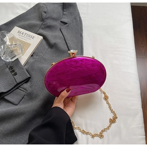 Detail of purple marbled acrylic evening bag with gold metal frame and crystal clasp