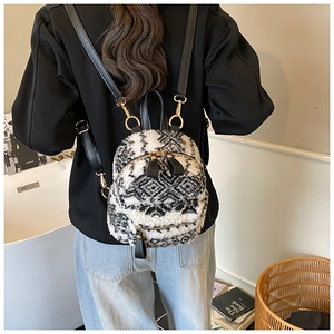 Detail eines flauschigen schwarz-weiß karierten Minirucksacks mit goldener Hardware