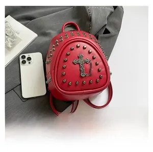 Détail du mini sac à dos gothique rouge avec croix métallique, clous et téléphone