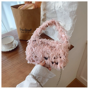 Close-up of pink feather handbag with sparkling sequins and fine metal chain strap