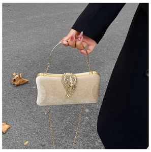 Detail of velvet champagne gold evening bag with gold leaf clasp and metal handle