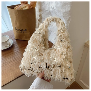 Detailed close-up of cream fuzzy handbag with golden sequins in a French cafe setting