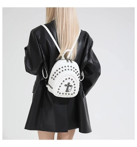 Détail du mini sac à dos blanc orné de rivets argentés et d'une chaîne en croix