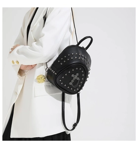 Close-up of gothic mini backpack featuring silver cross, metal chains and studs details