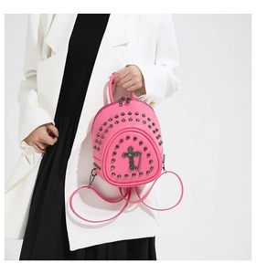 Détail du mini sac à dos punk rose avec clous argentés et pendentif croix gothique