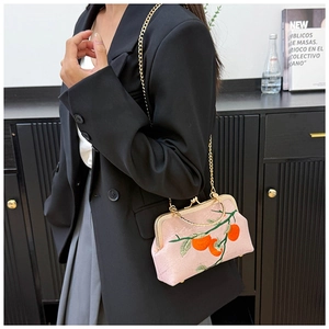 Pink embroidery handbag with persimmon pattern and gold chain strap shown on model