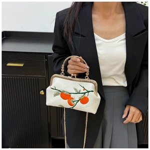 Detailed embroidery of orange persimmon pattern on vintage cream crossbody bag