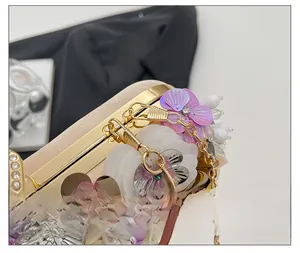 Detail of floral champagne evening bag with satin, sequins, pearls and gold chain
