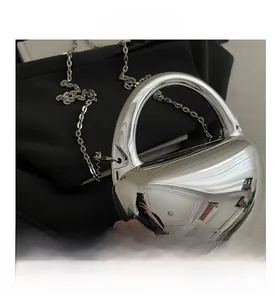 Vue détaillée de la surface miroir argentée et de la poignée en métal du mini sac boîte