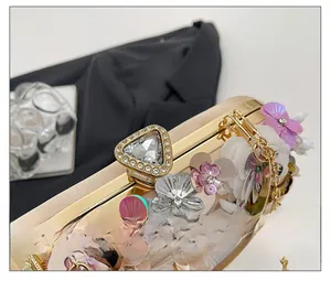 Macro detail of sequin floral embroidery and sparkling crystal clasp on the evening bag