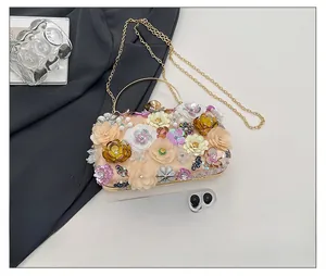 Detail of 3D floral beaded evening clutch with gold metal handle and chain strap