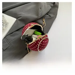 Macro detail of red polka dot ball clutch bag showing interior capacity for essentials