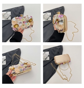 Detail view of 3D floral evening bag with metal handle, gold chain and sequins