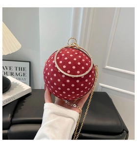 Close-up of a red polka dot sphere evening bag with a crystal-encrusted round handle