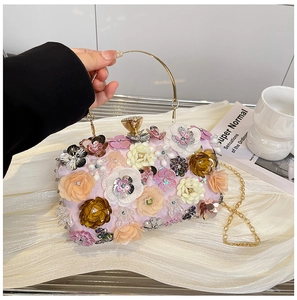 Detail of pink floral evening clutch with 3D petals and golden ring handle