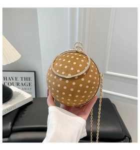 Detail of spherical brown suede evening bag with white polka dots and gold chain strap