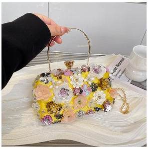 Macro shot of 3D yellow floral evening bag with gold handle and intricate sequin details