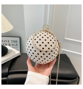 Detail of spherical evening bag with polka dots, metal ring handle and rhinestone accents