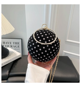 Detail of spherical evening bag with polka dots, diamond metal handle and gold chain