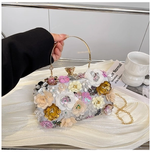 Detail view of 3D floral evening clutch with white petals and gold round metal handle
