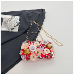 Detail of red floral evening clutch featuring 3D sequins and gold ring handle