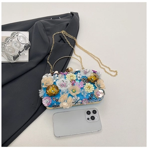 Detail view of royal blue satin evening clutch with 3D beaded flowers and metal handle
