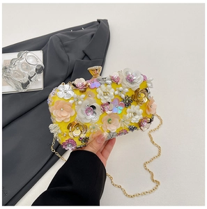 Detail of yellow handmade floral evening clutch with gold metal clasp and chain strap