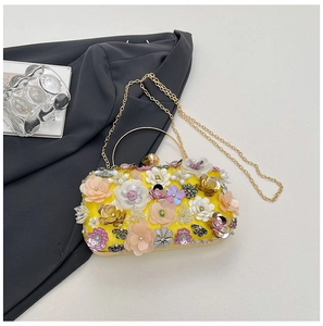 Detail of 3D yellow flower clutch bag with golden ring handle and chain strap
