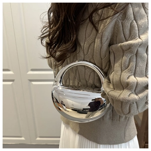 Gros plan d'un sac à main argenté en forme de demi-lune avec effet miroir sur un mannequin